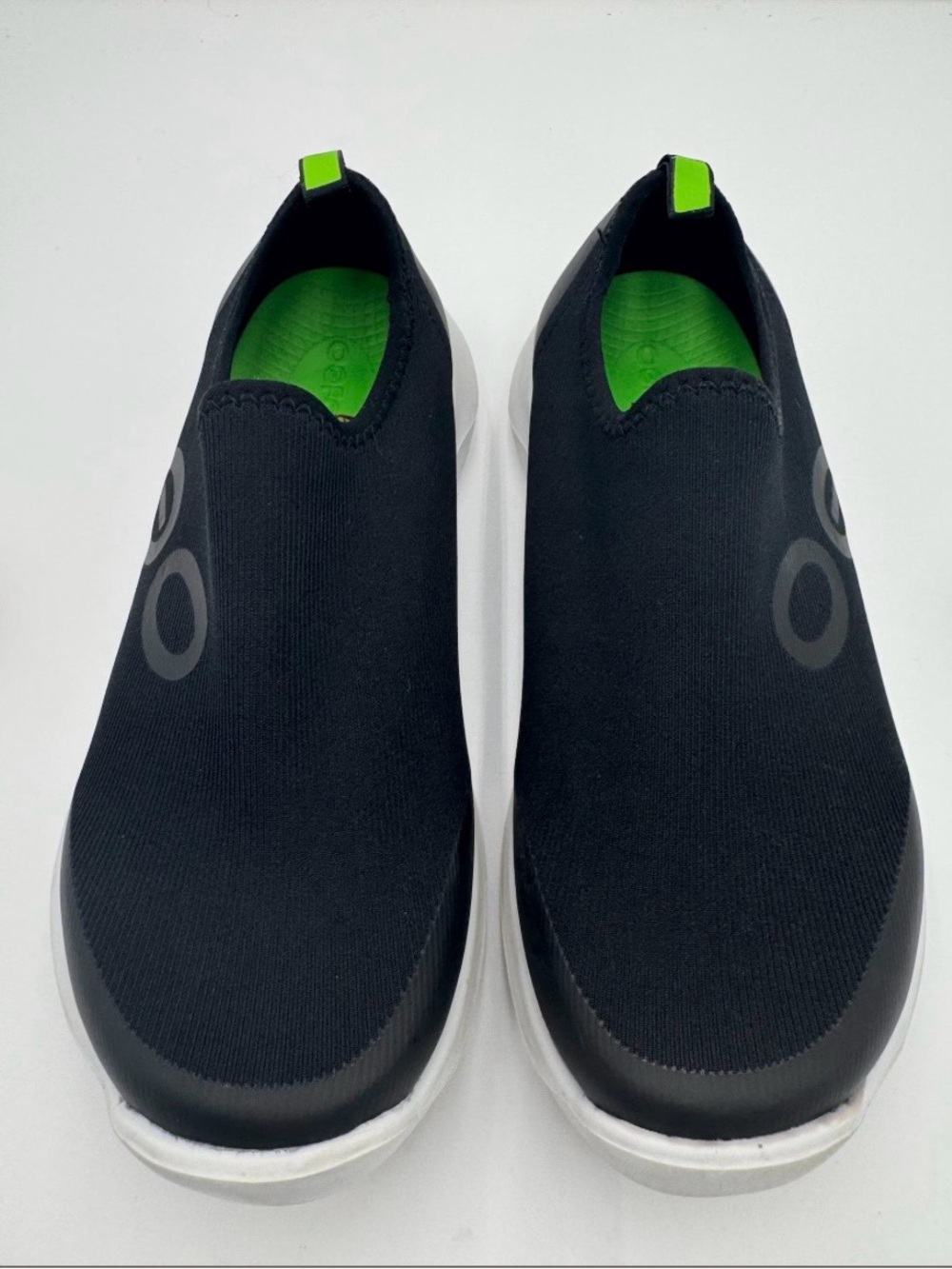 OOFOS OOMg Sport Women Slip-Ons in White and Black